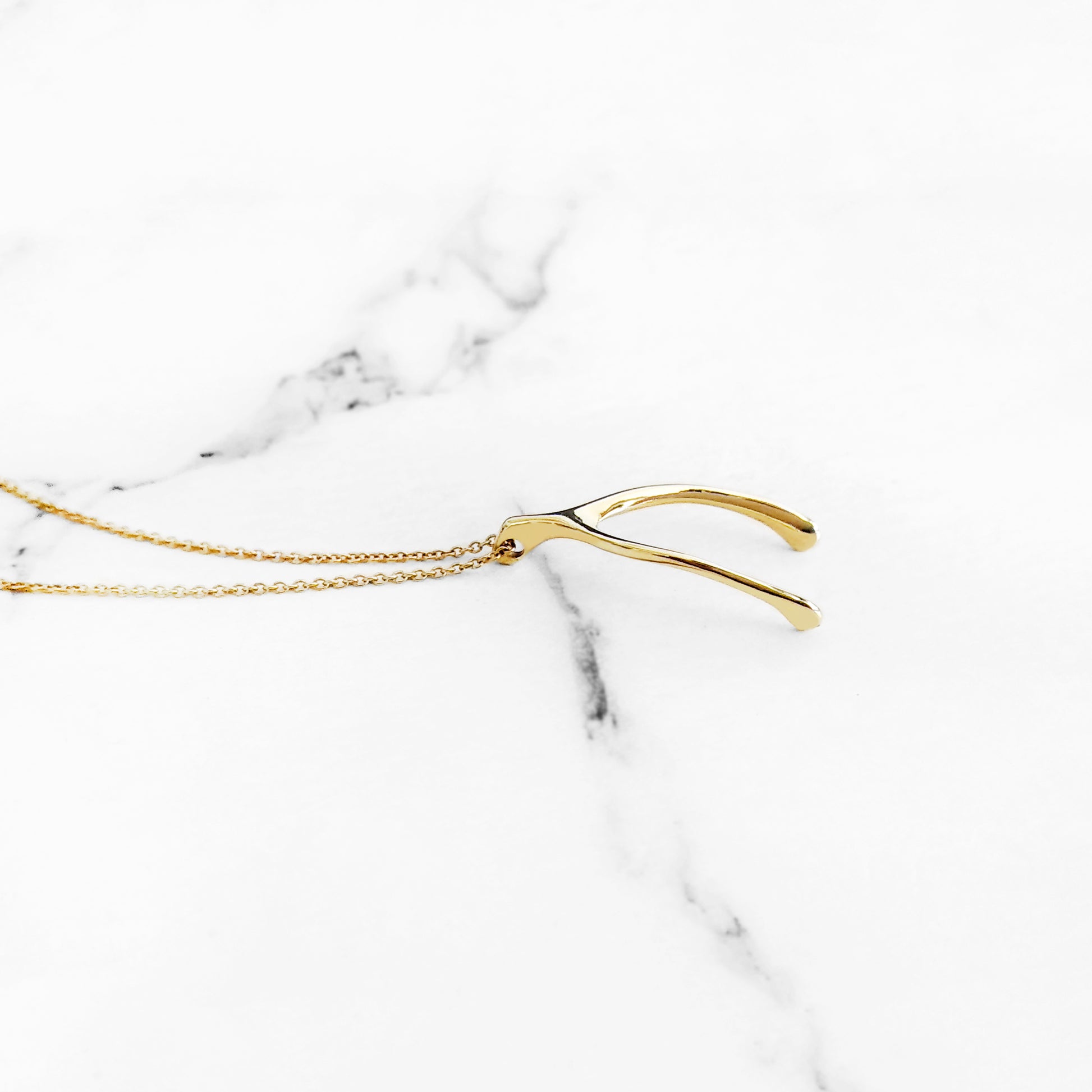 side view of solid yellow gold wishbone pendant necklace