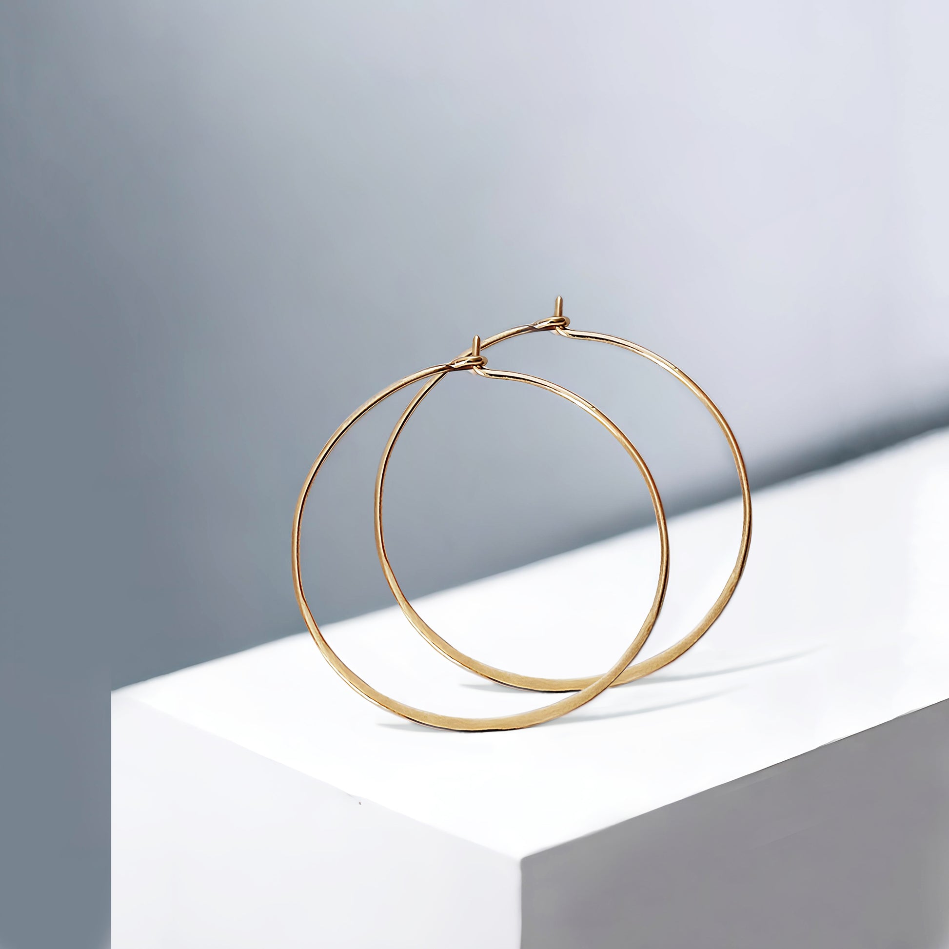 pair of yellow gold thin hoop earrings 40mm diameter and flattened bottom