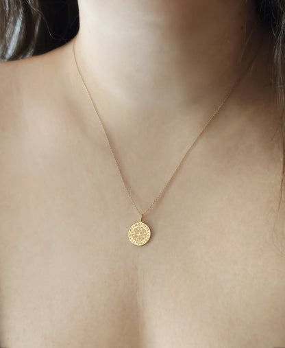 close up of a female neck wearing gold dara knot pendant necklace