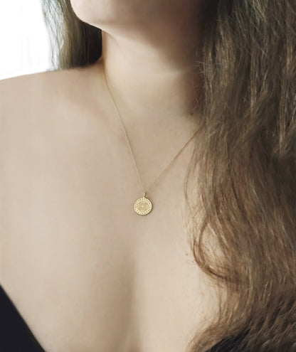 female wearing yellow gold dara knot pendant necklace 