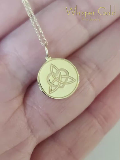 video of a gold disc pendant necklace engraved with a triquetra everlasting love celtic knot with a circle frame around it