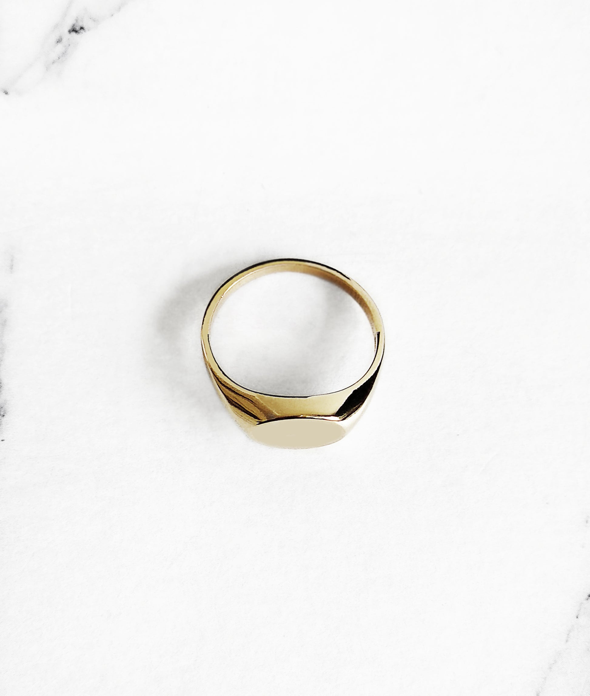 top view of a solid yellow gold dainty oval signet ring