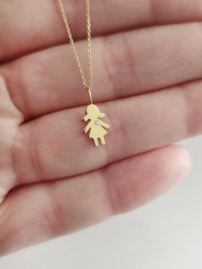 close up of a palm holding a gold necklace with a tiny girl outline charm set with a diamond for size reference