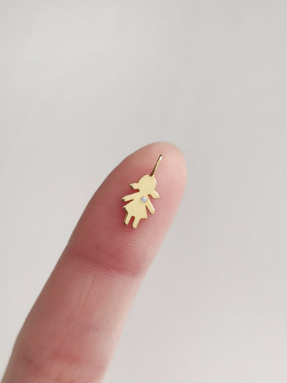 close up of a fingertip holding a tiny gold girl outline charm set with a tiny diamond for size reference