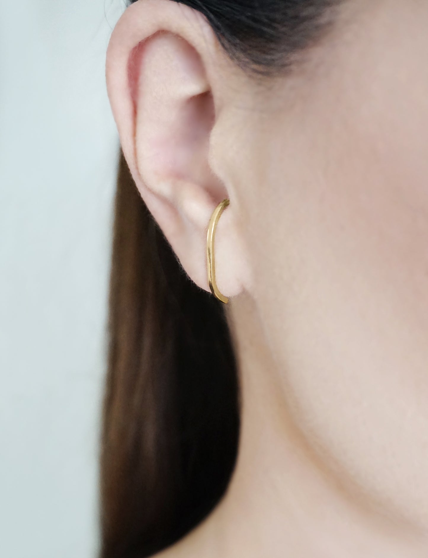 close up of a woman's ear wearing 25mm solid yellow gold earlobe cuff suspender earring