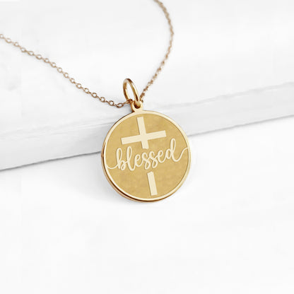 yellow gold necklace with a disc pendant engraved with the word blessed and a cross 